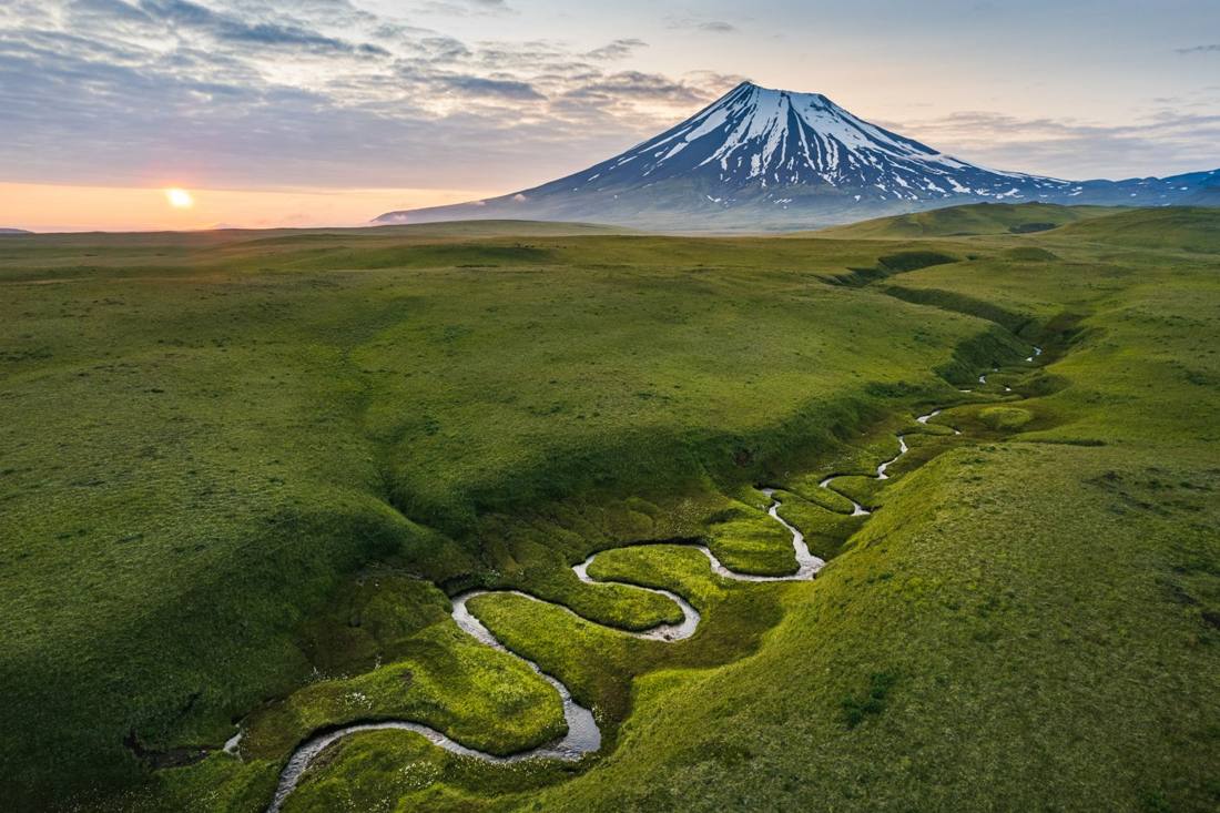 Green slopes of Umnak Island above the sea